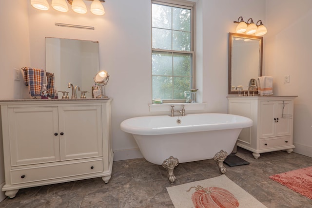 bathroom featuring a bathing tub, vanity, and a healthy amount of sunlight