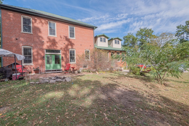 rear view of house featuring a lawn and a patio area