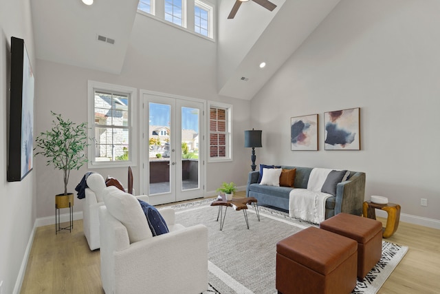 living room featuring french doors, ceiling fan, high vaulted ceiling, and light wood-type flooring