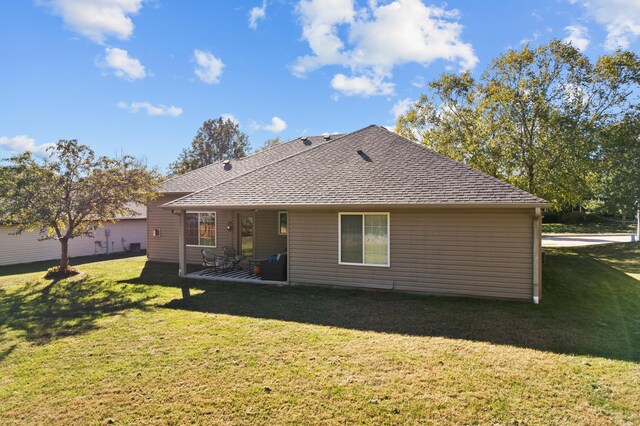 rear view of house featuring a patio area and a lawn