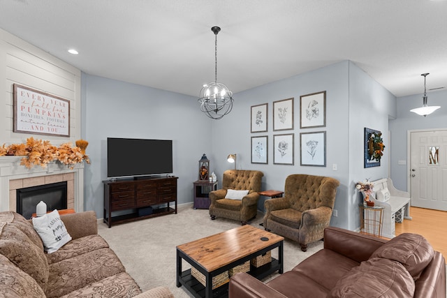 carpeted living room with a notable chandelier and a tile fireplace