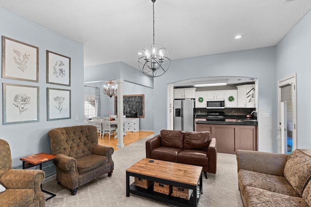 living room featuring light hardwood / wood-style flooring, a chandelier, and sink