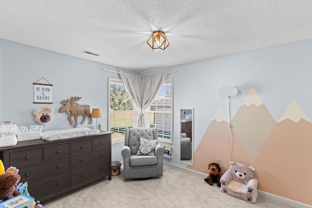 bedroom with a textured ceiling and light colored carpet