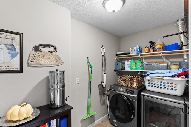 laundry room featuring a textured ceiling and washer and clothes dryer