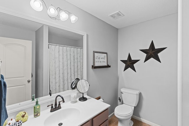 bathroom with vanity, a textured ceiling, toilet, and tile patterned floors