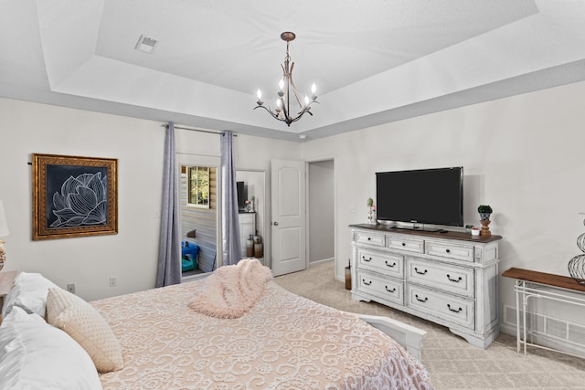 carpeted bedroom featuring a chandelier and a tray ceiling