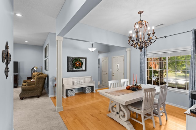 dining room with a notable chandelier, a textured ceiling, and hardwood / wood-style floors