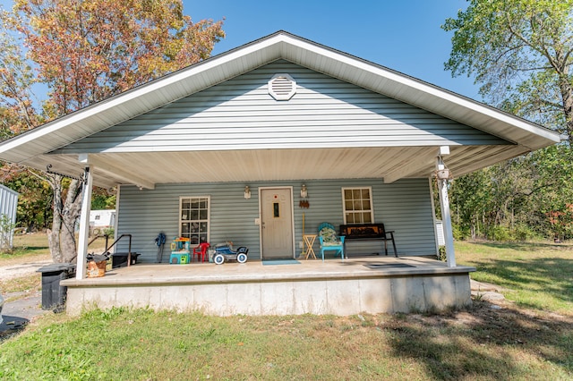 rear view of property with a porch and a lawn