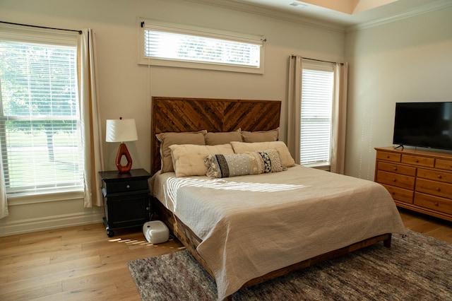 bedroom featuring light hardwood / wood-style flooring and crown molding