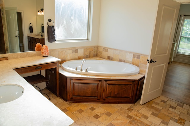 bathroom with vanity and a tub to relax in