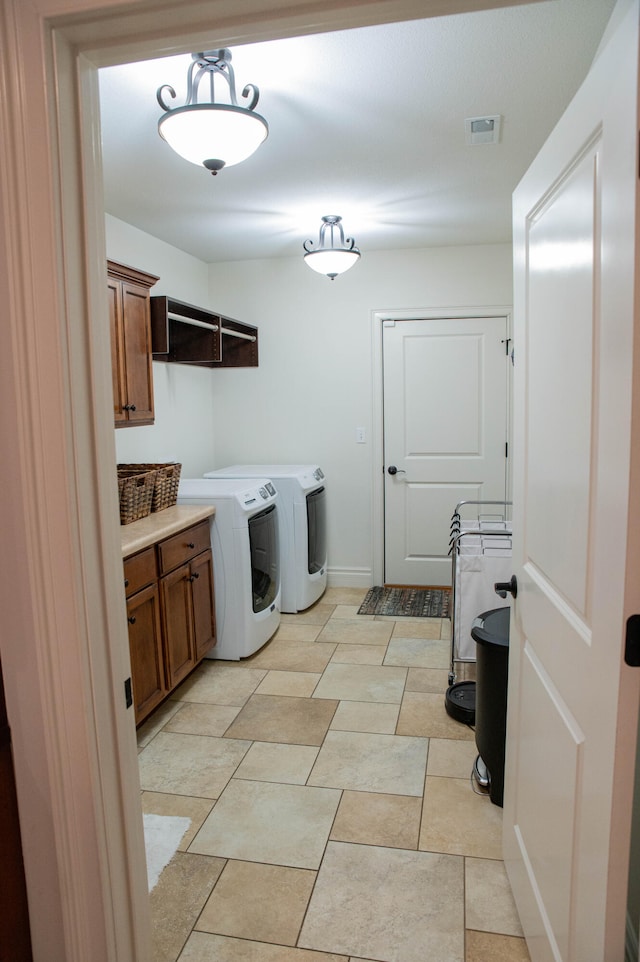 laundry room featuring cabinets and separate washer and dryer