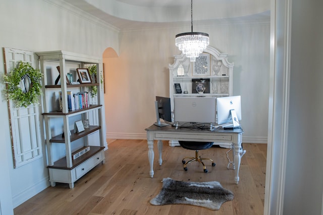 home office featuring crown molding, a chandelier, and light wood-type flooring