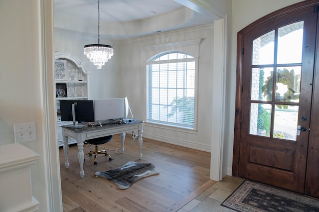 office space featuring a wealth of natural light, a chandelier, light hardwood / wood-style flooring, and a tray ceiling