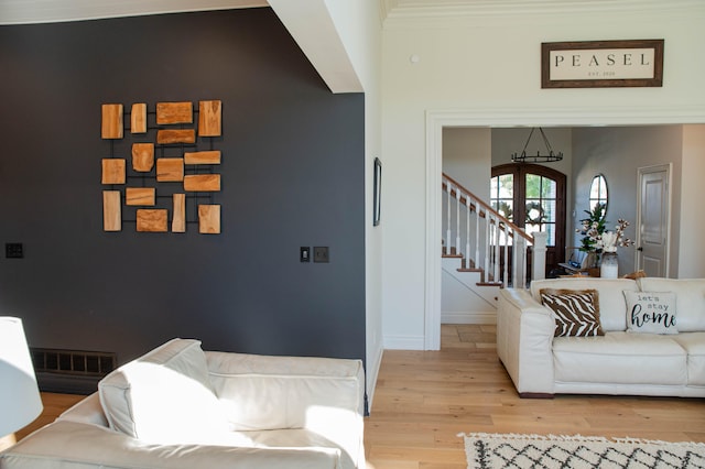 living room with ornamental molding and light wood-type flooring