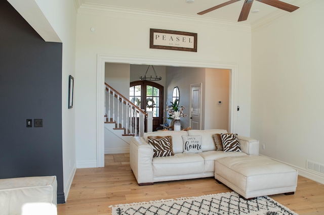 living room with french doors, crown molding, light hardwood / wood-style flooring, and ceiling fan