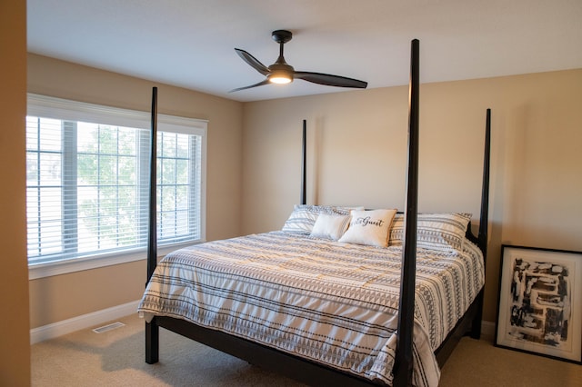 carpeted bedroom featuring multiple windows and ceiling fan