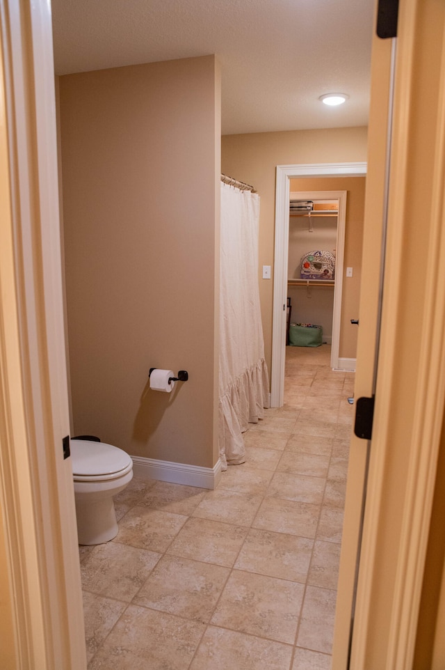 bathroom featuring toilet and tile patterned flooring