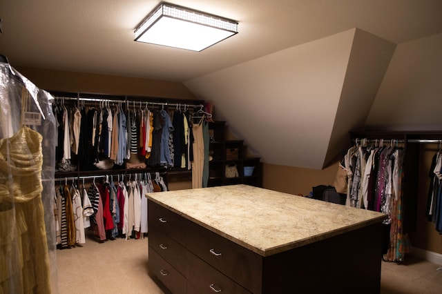 walk in closet with light carpet and lofted ceiling