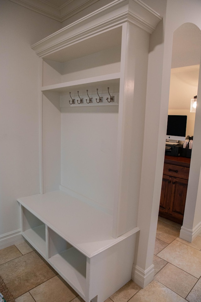 mudroom featuring crown molding and light tile patterned floors