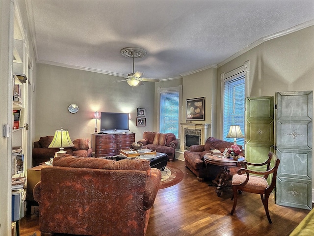 living room with ornamental molding, a textured ceiling, wood-type flooring, and ceiling fan