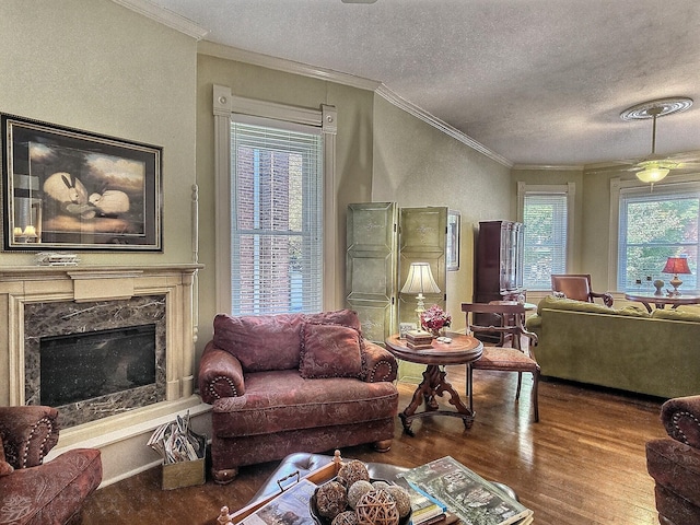 living room with crown molding, hardwood / wood-style flooring, a textured ceiling, and a high end fireplace