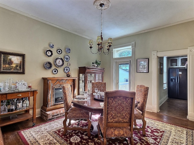 dining room featuring dark wood-type flooring, crown molding, and a notable chandelier