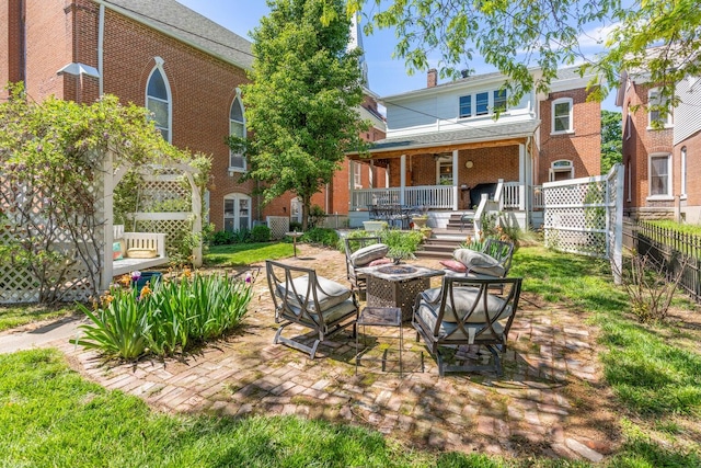 back of property with a patio, an outdoor fire pit, and a porch