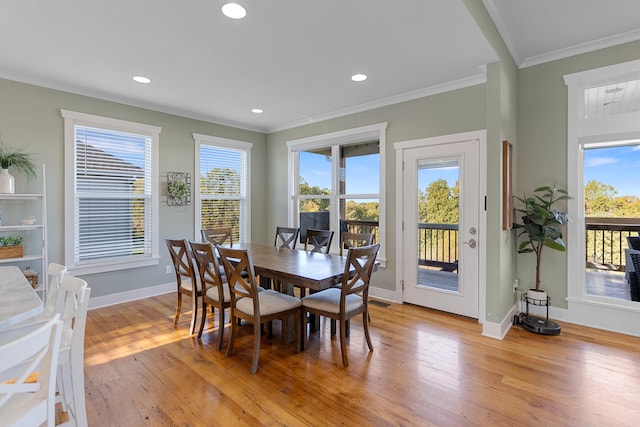 dining room with light hardwood / wood-style flooring, plenty of natural light, and crown molding