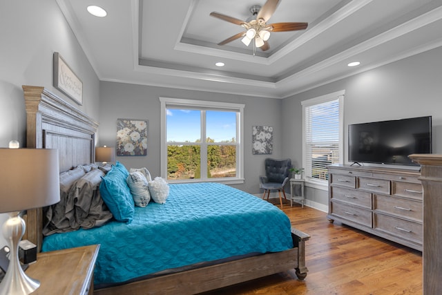 bedroom with ceiling fan, crown molding, multiple windows, and light wood-type flooring