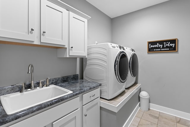 washroom with sink, washer and clothes dryer, light tile patterned floors, and cabinets