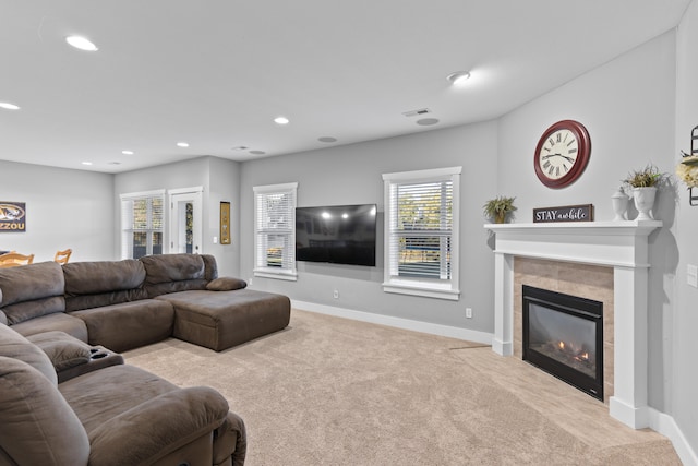 living room with a wealth of natural light, light carpet, and a fireplace