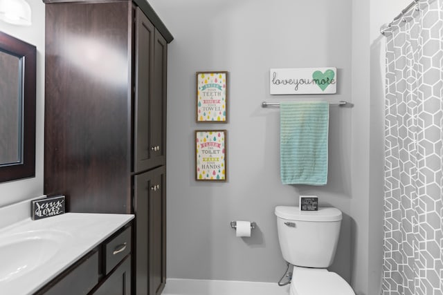 bathroom featuring toilet, vanity, and a shower with shower curtain