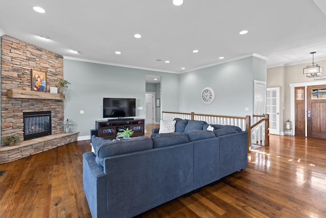 living room featuring dark wood-type flooring, crown molding, and a fireplace