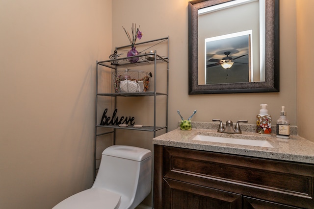 bathroom with vanity, toilet, and ceiling fan