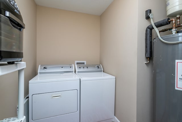 washroom featuring water heater and washing machine and clothes dryer