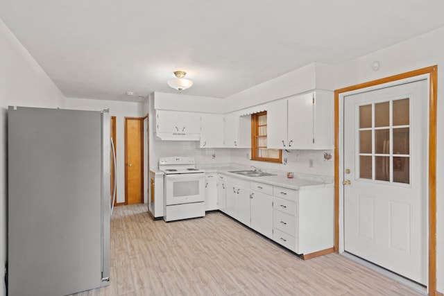 kitchen with white appliances, backsplash, white cabinets, sink, and light wood-type flooring