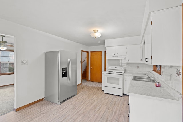 kitchen featuring stainless steel fridge, tasteful backsplash, sink, white range with electric cooktop, and white cabinetry