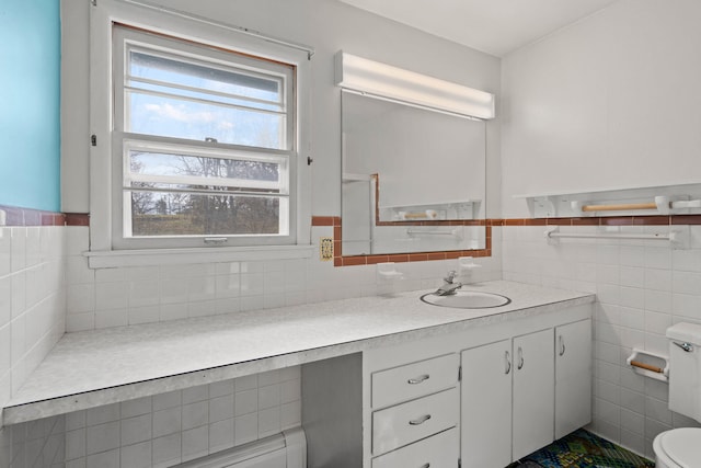 bathroom with vanity, tile walls, and toilet