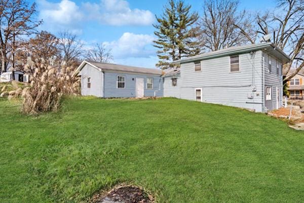 rear view of house featuring a yard