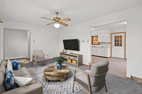 living room with ceiling fan and a baseboard heating unit