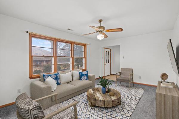 carpeted living room with ceiling fan