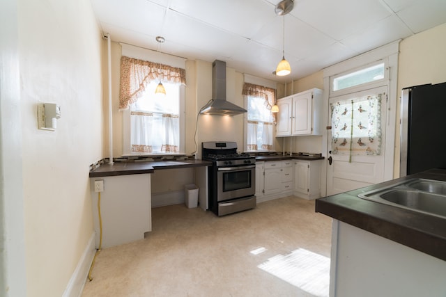 kitchen with sink, decorative light fixtures, wall chimney range hood, stainless steel appliances, and white cabinets