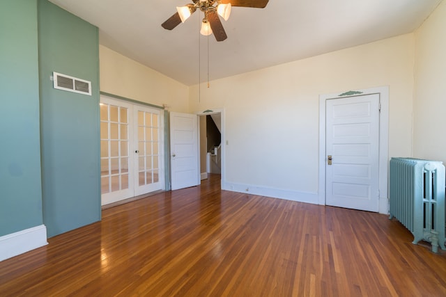 unfurnished room with radiator heating unit, dark hardwood / wood-style floors, ceiling fan, and french doors