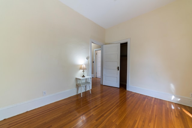 unfurnished bedroom with dark wood-type flooring