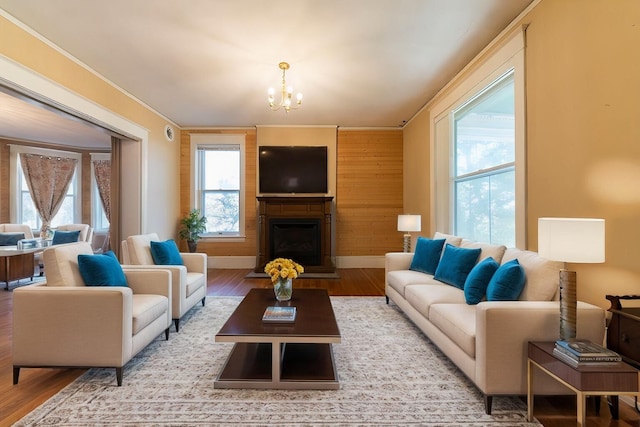 living room featuring crown molding, a notable chandelier, and light wood-type flooring