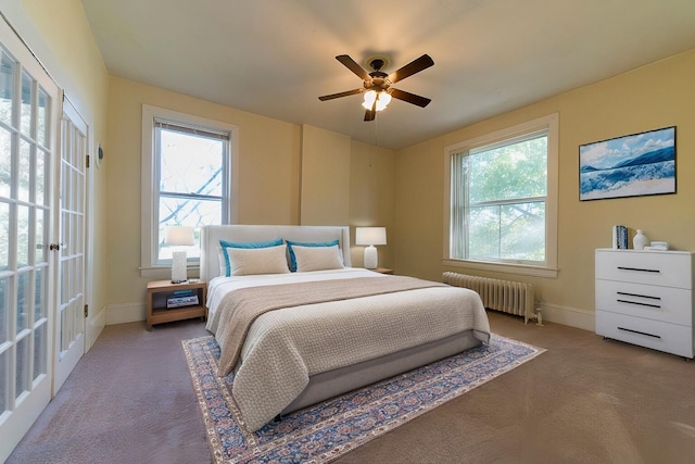 bedroom featuring ceiling fan, radiator heating unit, carpet flooring, and multiple windows