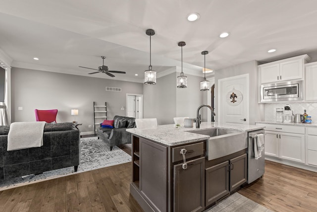 kitchen featuring white cabinets, hanging light fixtures, dark hardwood / wood-style flooring, sink, and stainless steel appliances