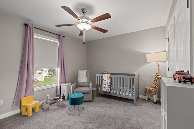 bedroom featuring light carpet, a crib, and ceiling fan