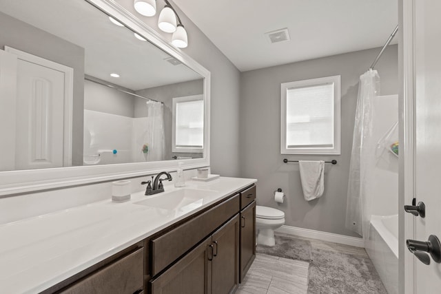 full bathroom featuring vanity, shower / tub combo with curtain, toilet, and plenty of natural light