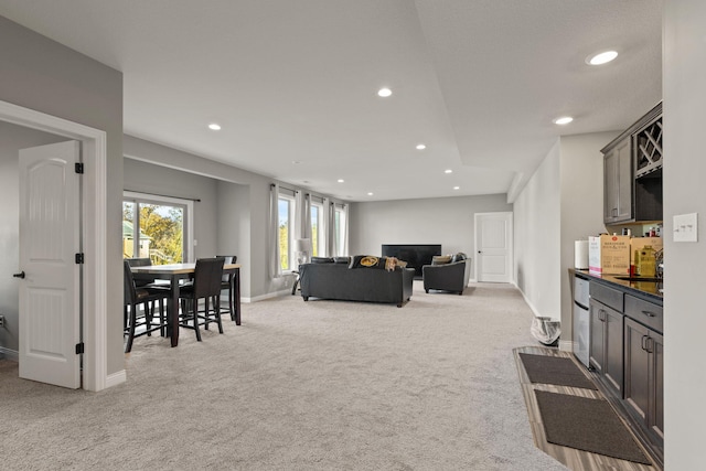 living room with light colored carpet and sink